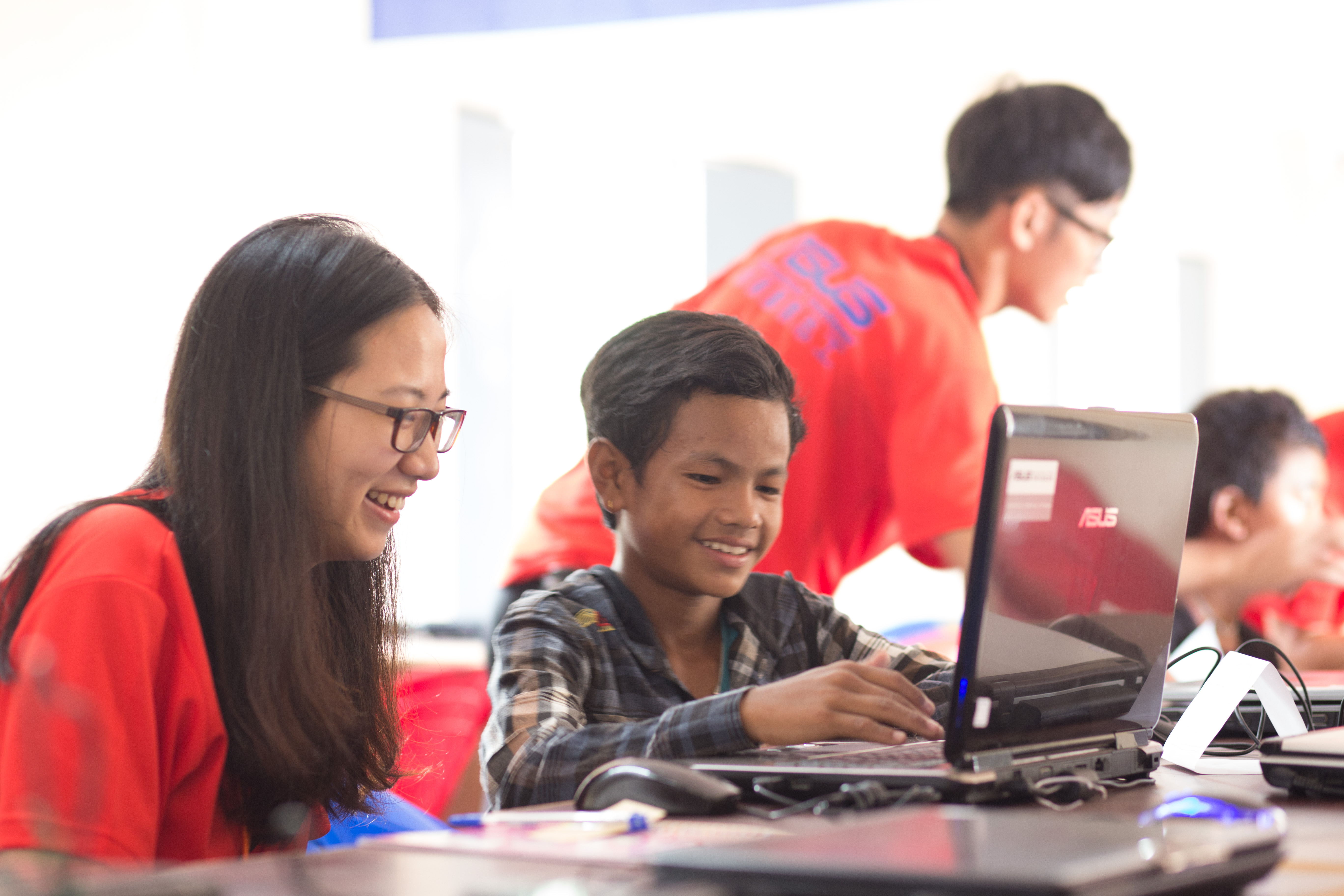 團員段鑫杰(左1)使用華碩華碩文教基金會捐贈的再生筆電，教導當地學童如何使用操作基本軟體。