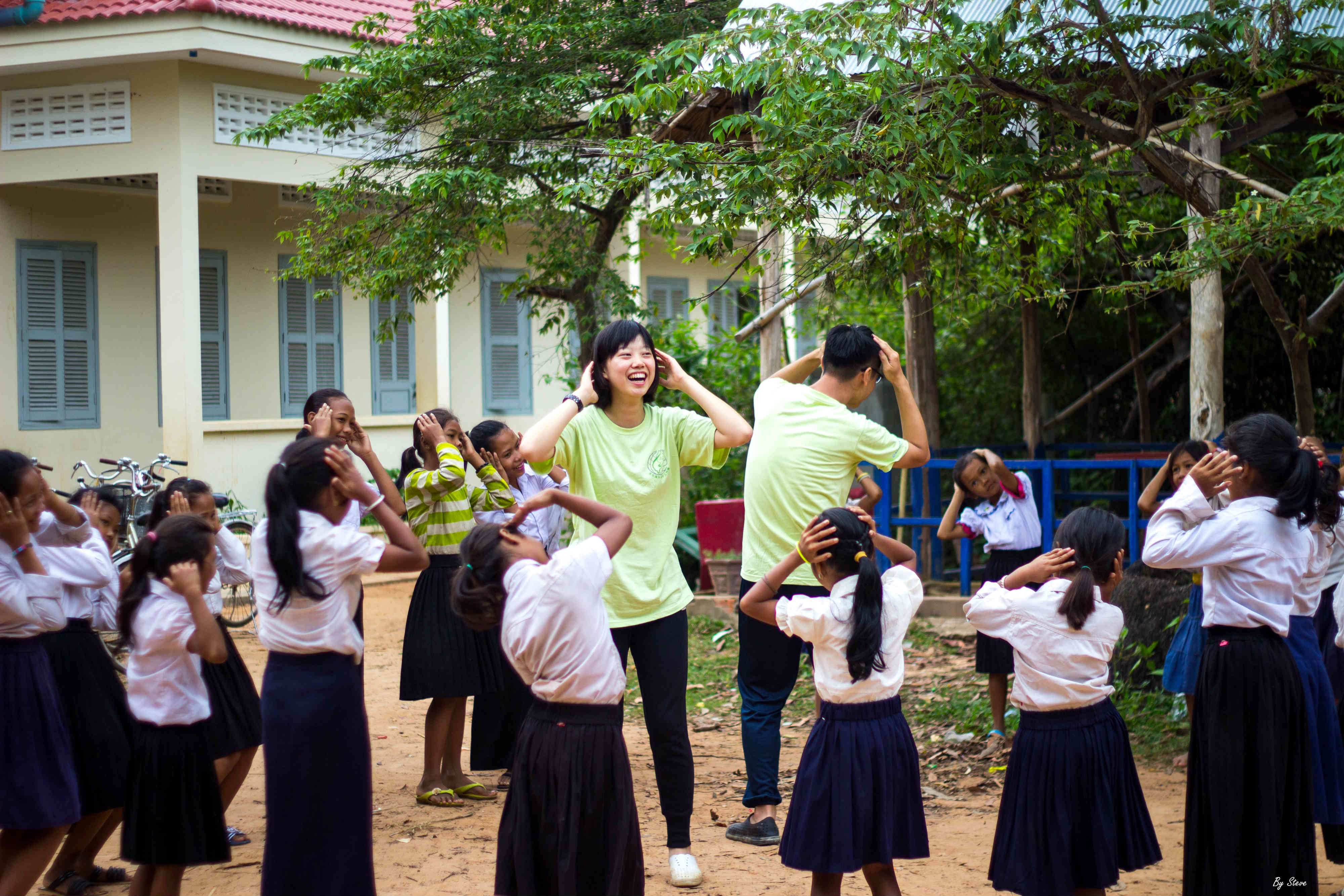 團員詹育潔(左1)和周雍倫(左2)利用早晨時光，在柬埔寨Tayek國小與學童一起帶動跳