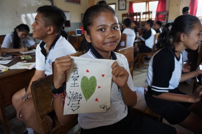 照片一：DIY麻布袋的課程中，當地學童在自製的環保麻布袋上畫上愛心並寫上「臺灣」兩字。