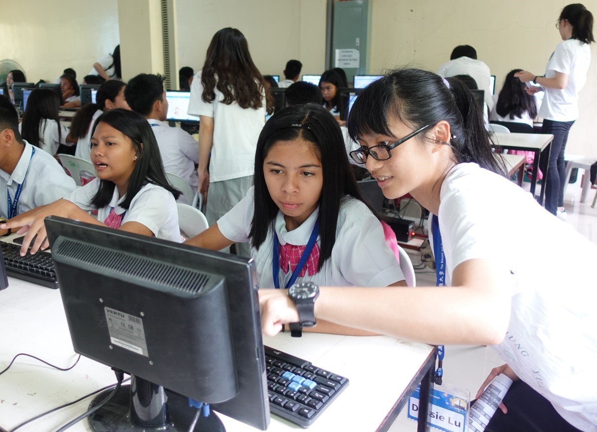 照片一：中原大學菲律賓國際志工資訊教育團隊員回答學員資訊課程問題