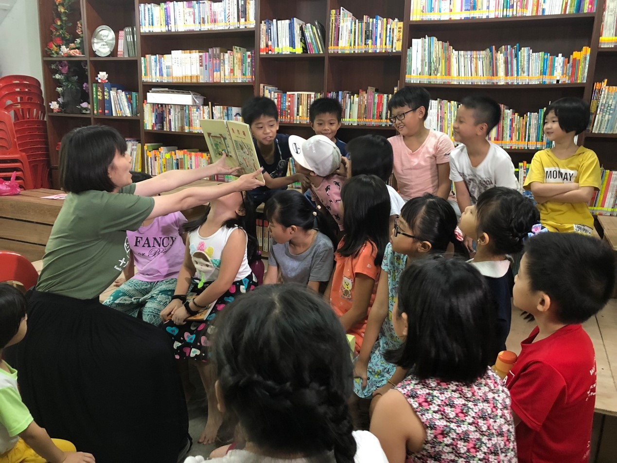 照片一：團員在十八丁圖書館分享繪本-《魚市場》，與小朋友互動熱列。