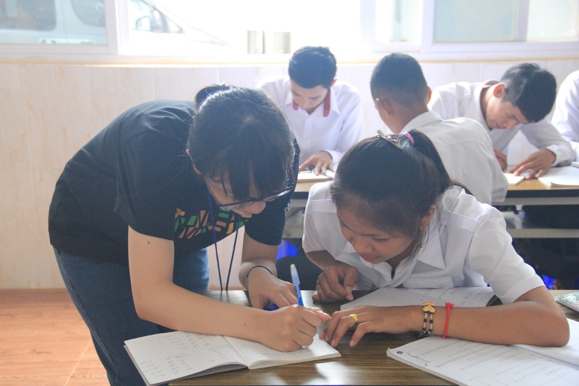 照片二：團員過去至柬埔寨教學中文，指導學生注音符號的寫法。