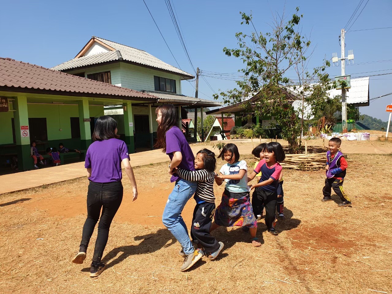 到泰語學校帶著孩子們玩老鷹抓小雞促進感情 。李文瑜(左) 李怡潔(右)