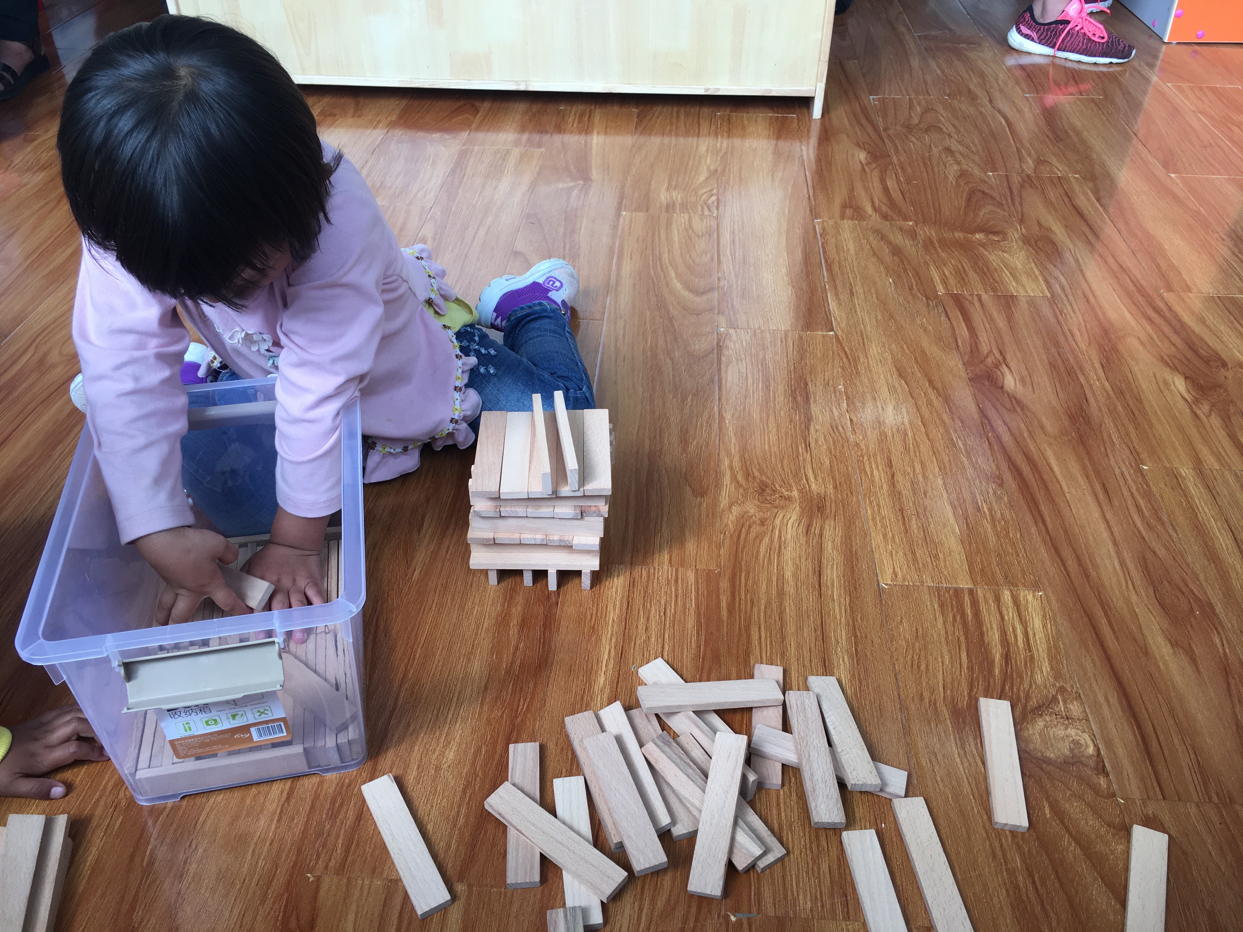 在建構角，孩子學習如何收積木