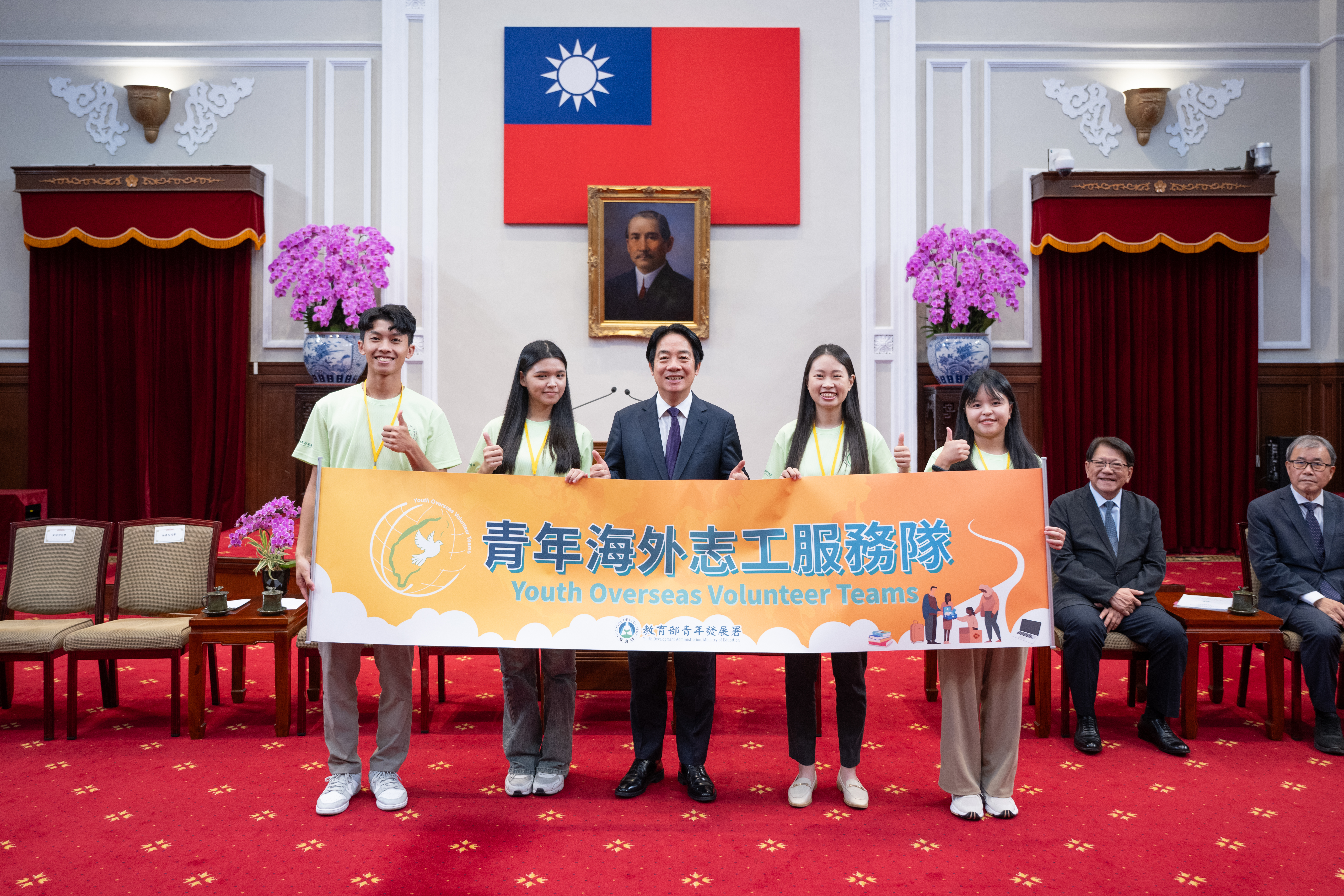 賴總統和四位青年志工代表授旗後合影，由左至右為紀冠宇、吳閩卉、李盈萱和林喬安